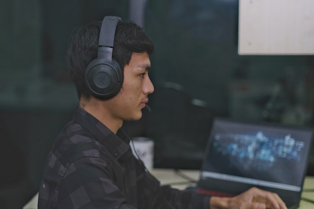 a man wearing headphones is using a laptop