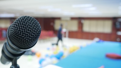 A wireless microphone resting on a stand beside a vibrant birthday cake.