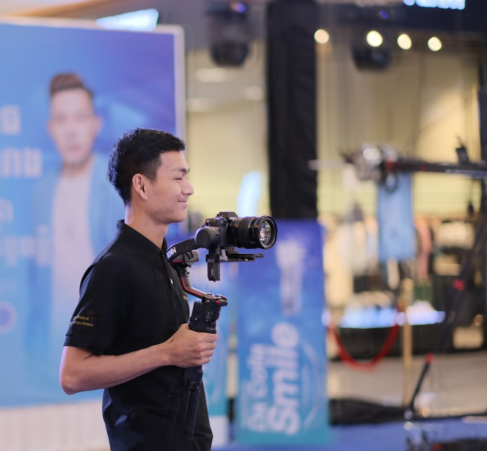 Un hombre parado frente a una cámara sosteniendo una cámara