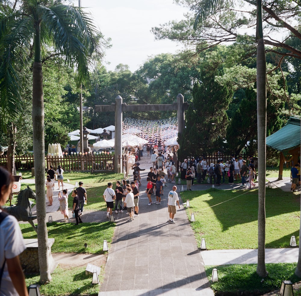 a group of people walking down a path in a park