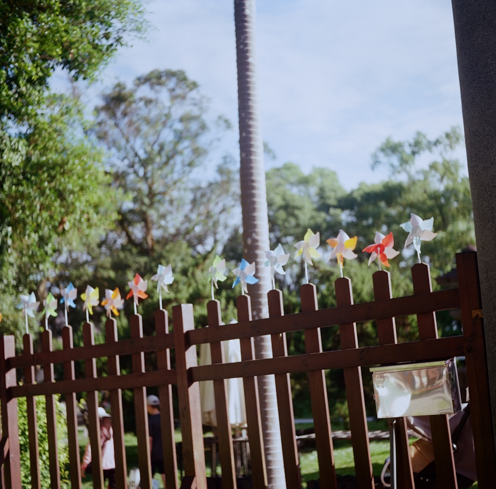 a wooden fence with pinwheels attached to it