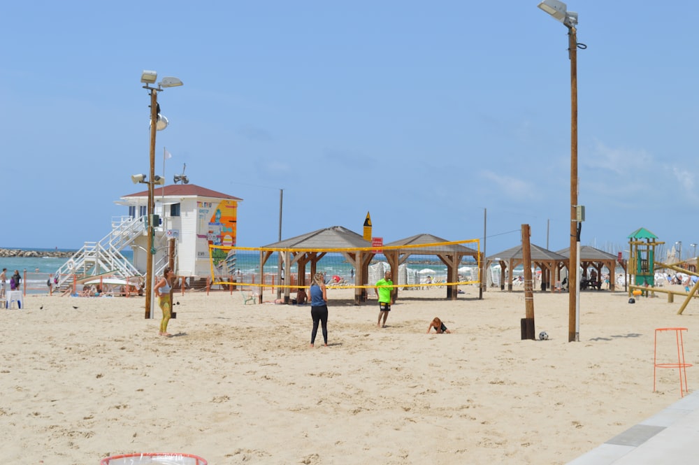 a group of people standing on top of a sandy beach