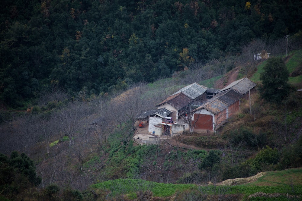 an old house on a hill with trees in the background