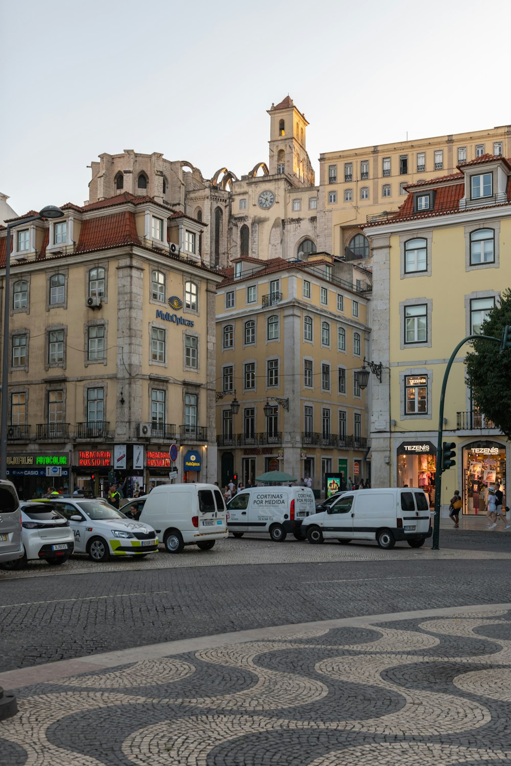 a city street filled with lots of traffic next to tall buildings