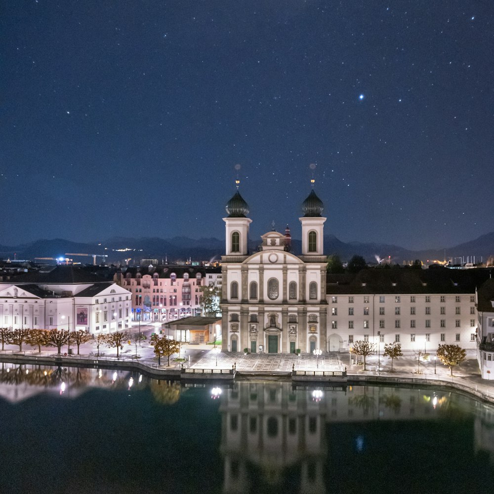 Una veduta notturna di un grande edificio con una torre dell'orologio