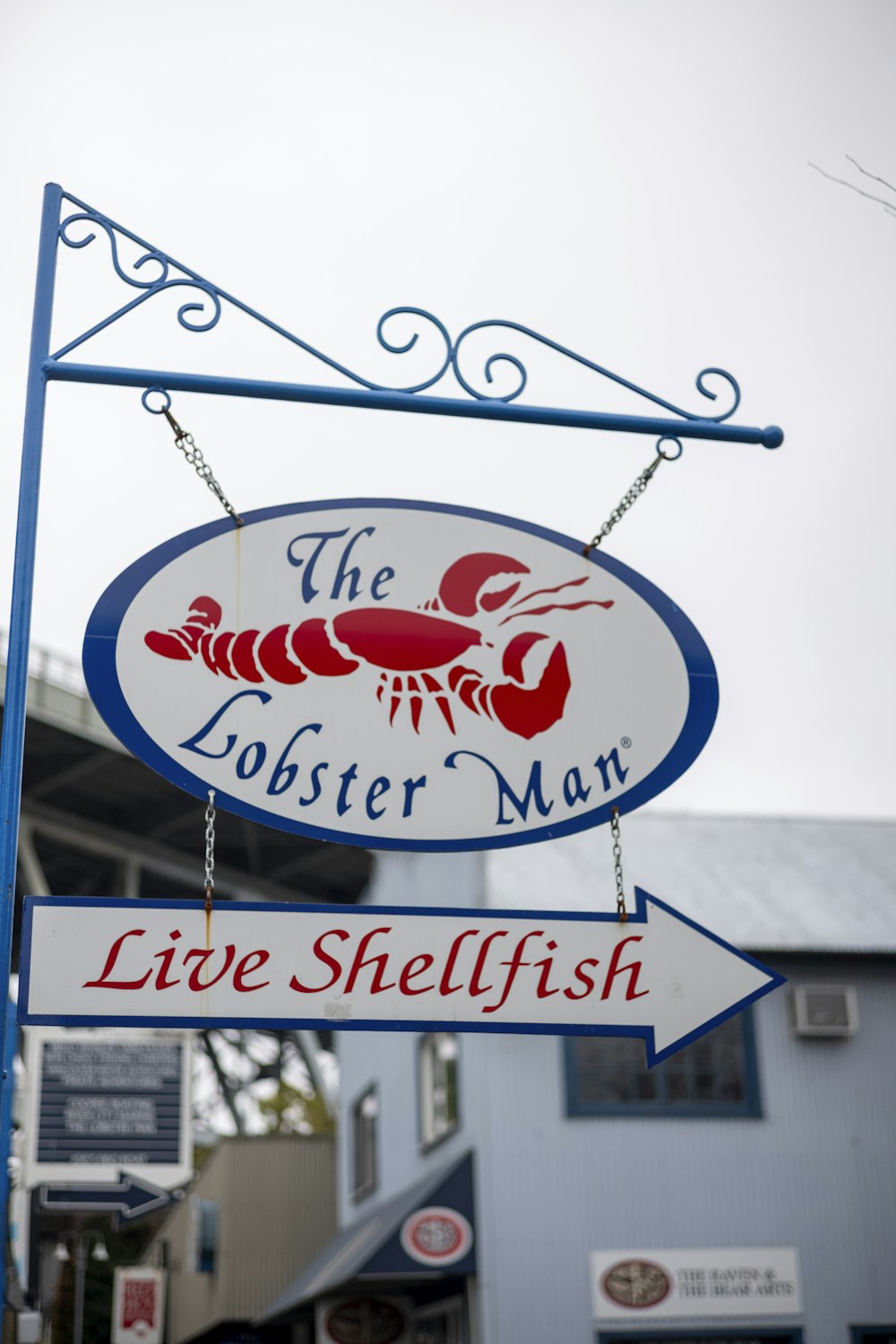 the lobster man sign is hanging from the side of the building