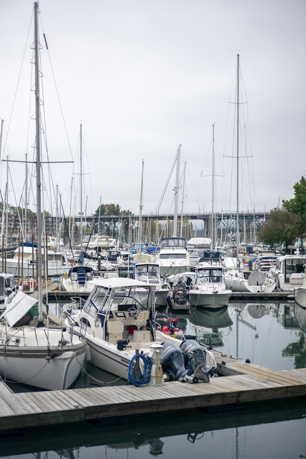 a marina filled with lots of boats on a cloudy day