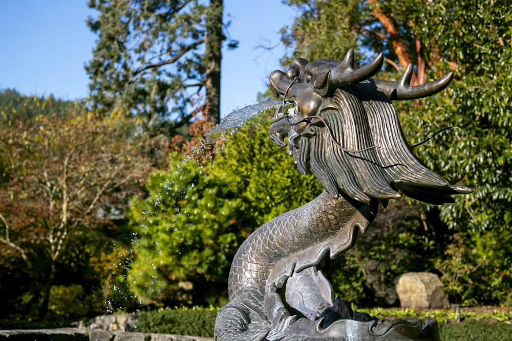 une fontaine d’eau avec une statue d’une tête d’homme crachant de l’eau