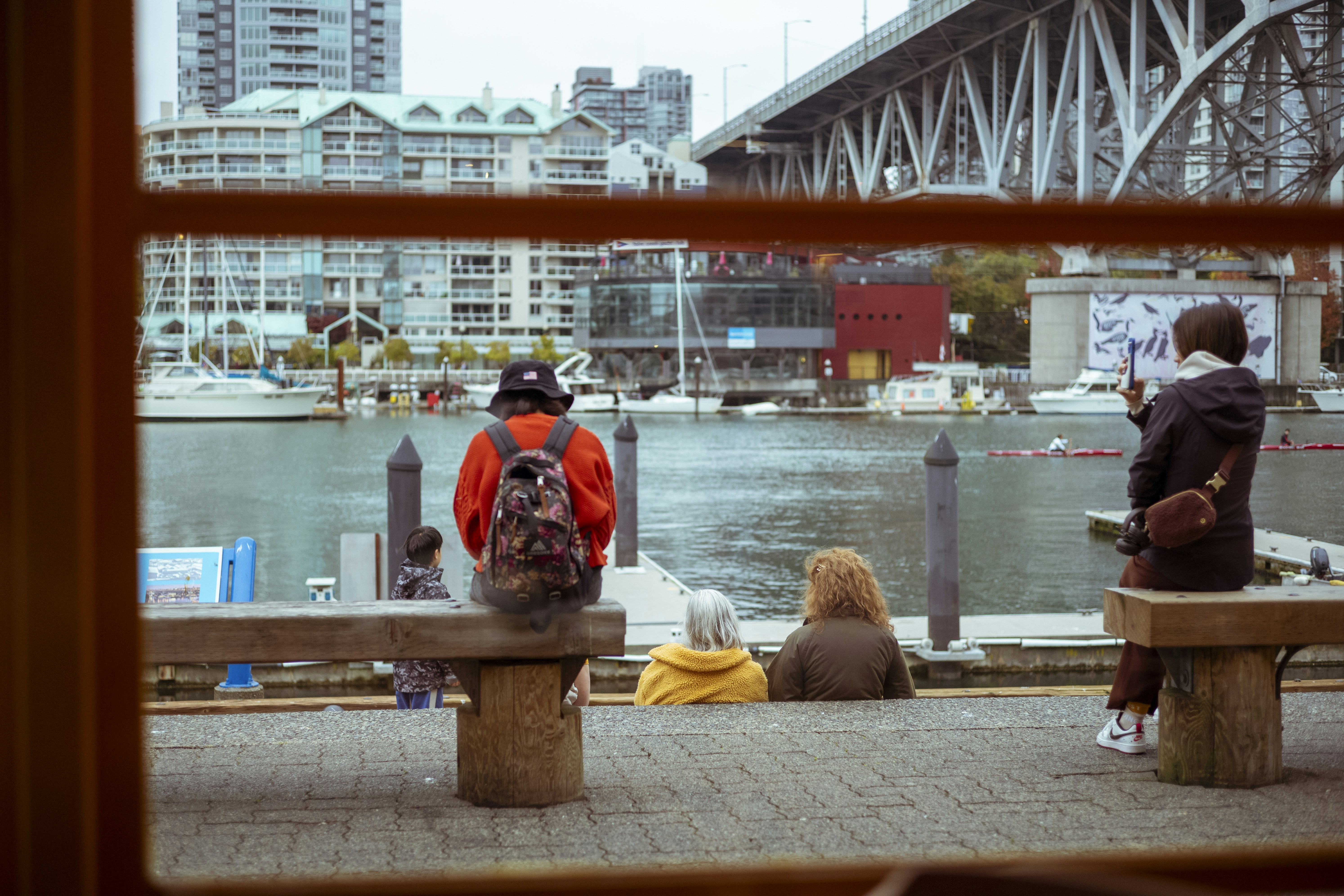 a group of people sitting on top of a wooden bench