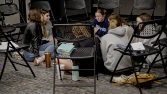a group of girls sitting in a room next to each other