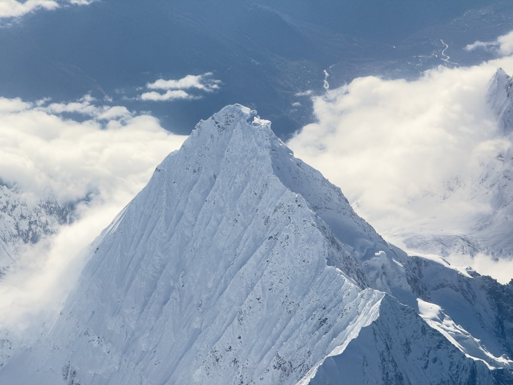 a very tall snow covered mountain with a sky background