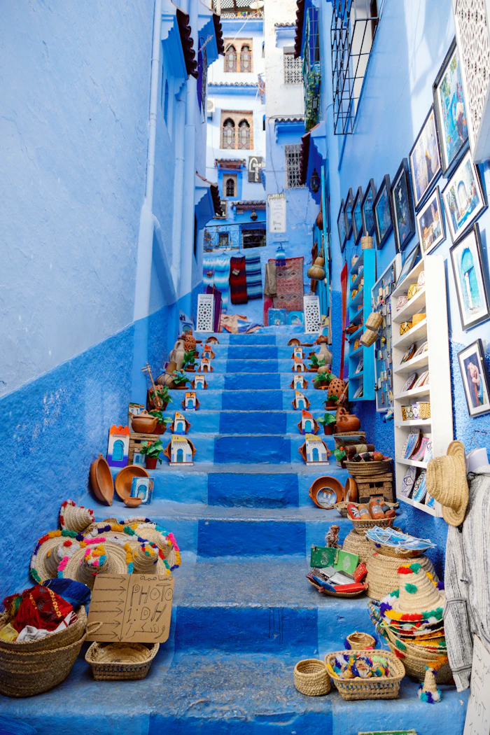 Blue-painted staircase with baskets in Chefchaouen, Morocco