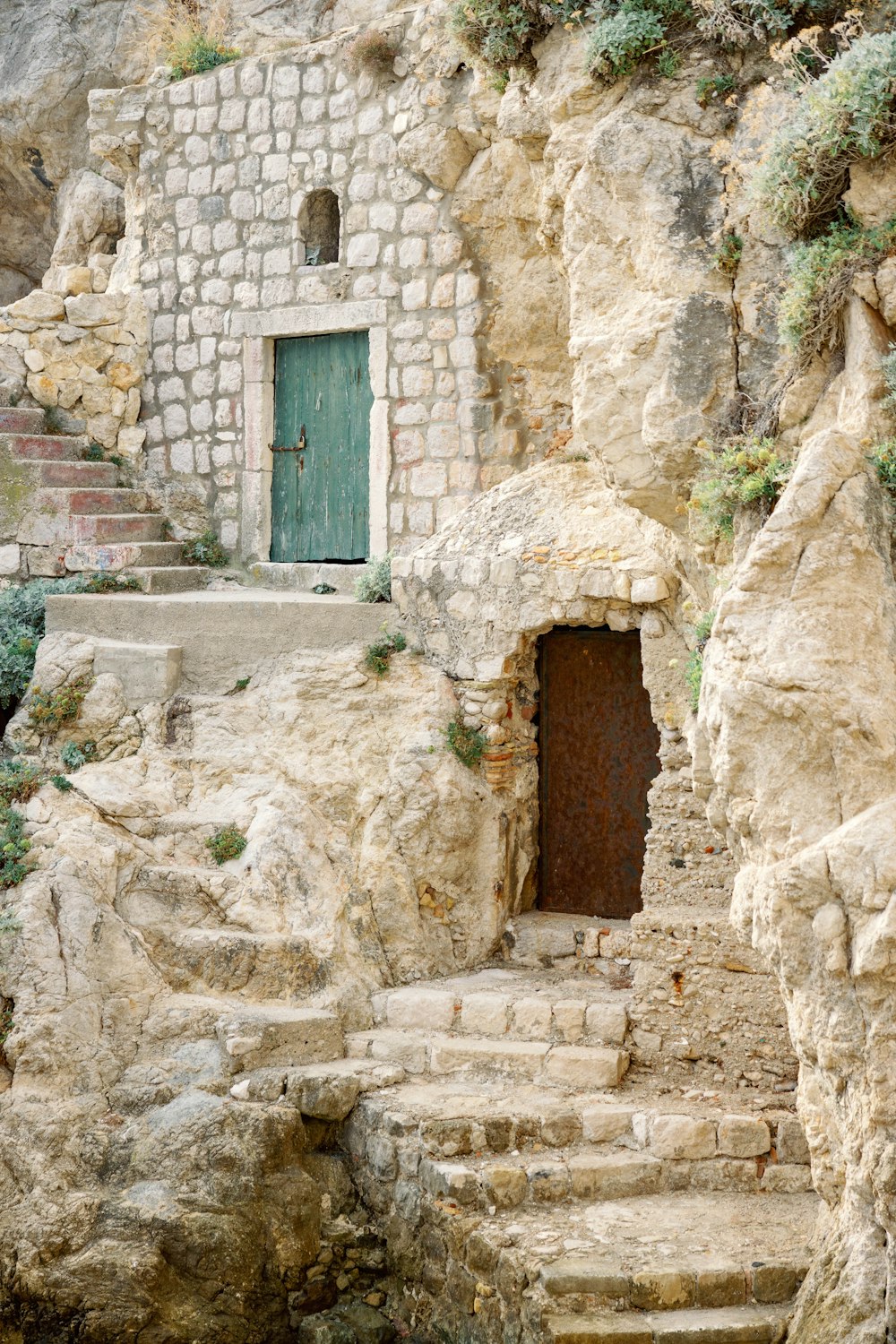 a stone building with a green door and steps