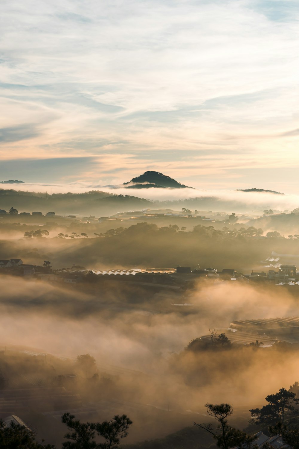 a foggy landscape with a small island in the distance