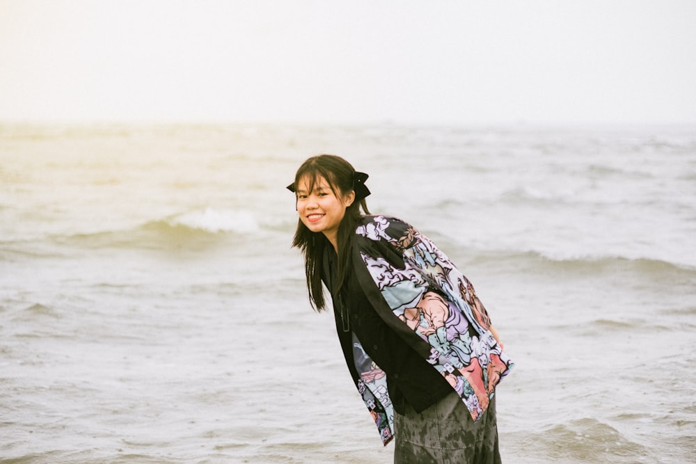 a woman standing in the ocean holding a surfboard