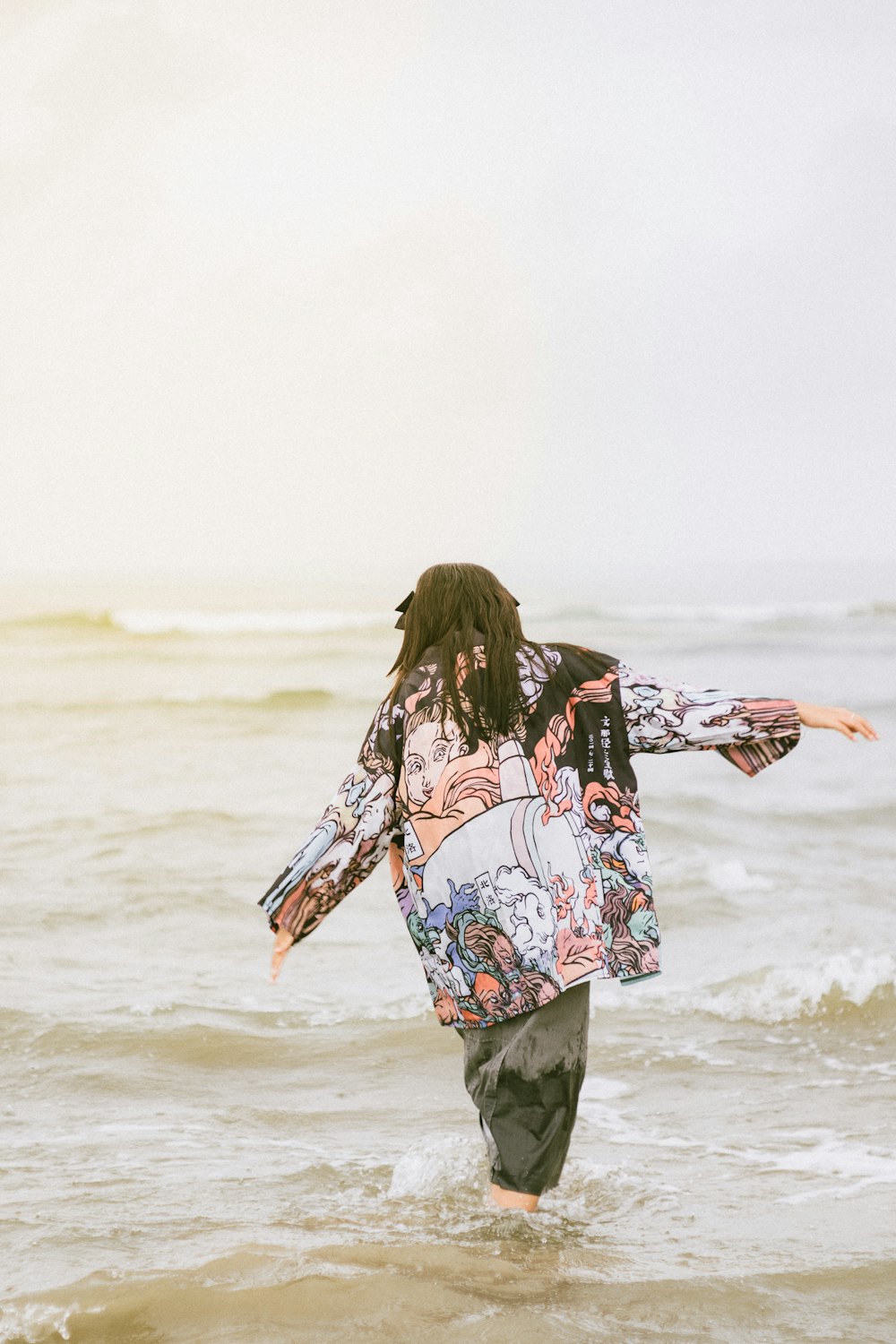 a person walking in the water on a beach