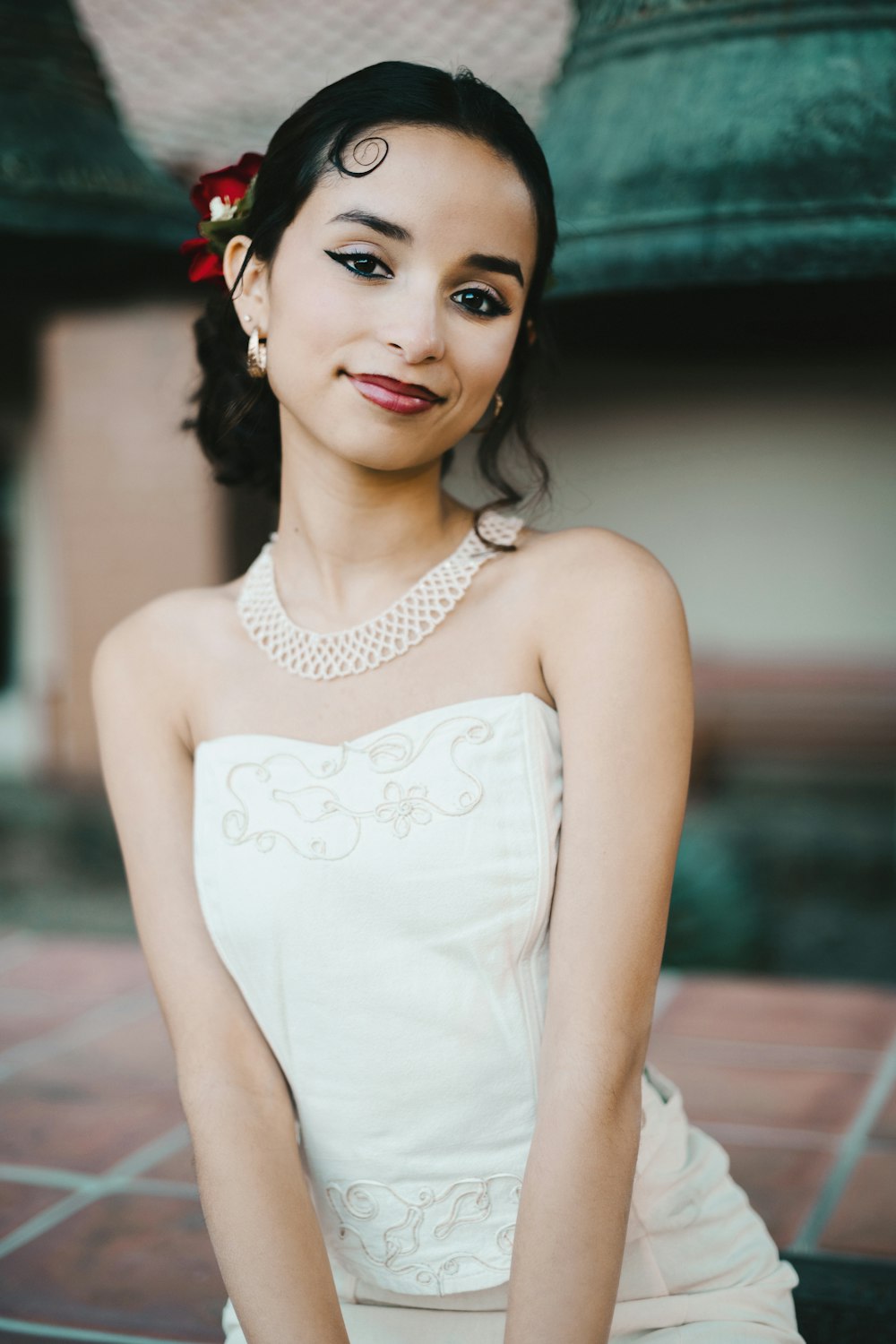 a woman in a white dress sitting on the ground