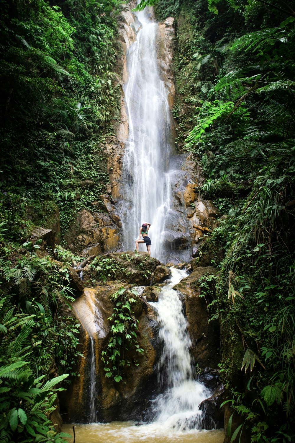 a man standing in front of a waterfall