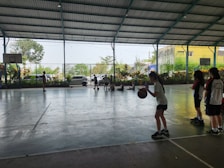 Children playing badminton in the farm’s sports arena surrounded by open fields and farm animals.