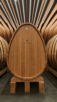Rustic wooden barrel with Viña Chouzal label in a minimalist cellar.