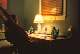 A person stretching beside their workstation, demonstrating a quick break to ease tension.