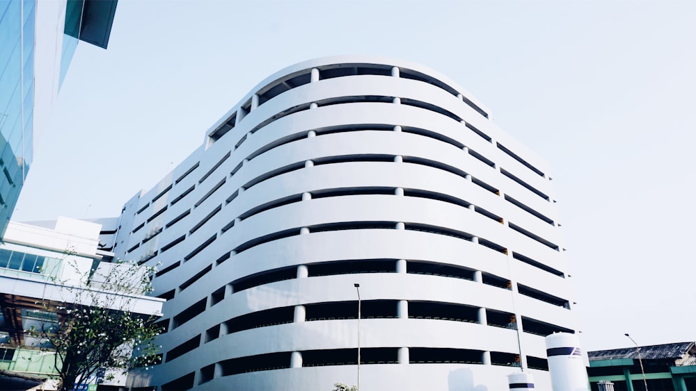 a tall white building sitting next to a tall building