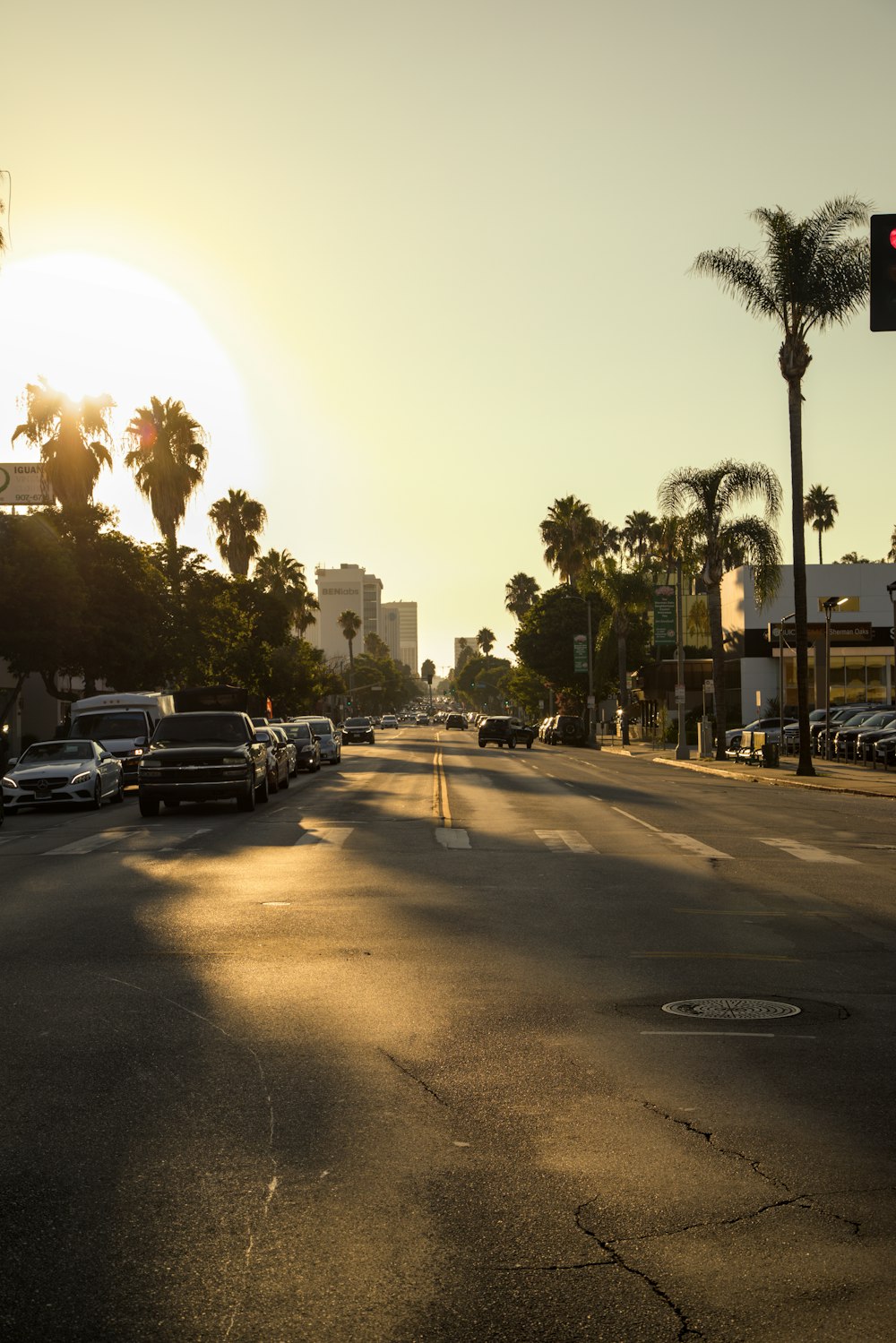 the sun is setting over a city street