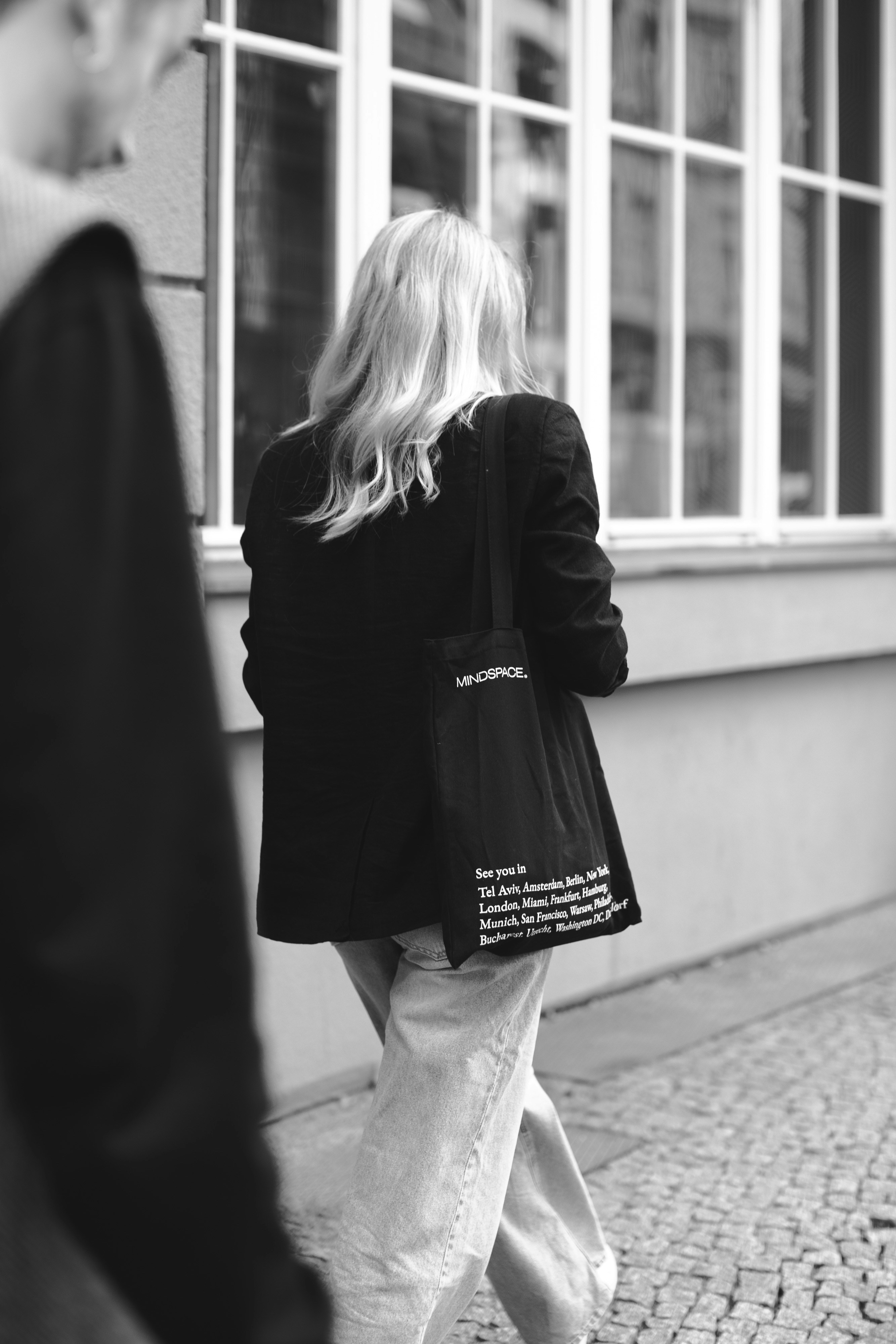A woman walking down a street carrying a black bag photo Free Germany