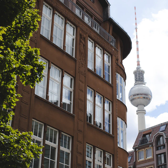 A tall brown building on Münzstrasse in Berlin Mitte with the Fernsehturm TV tower behind it