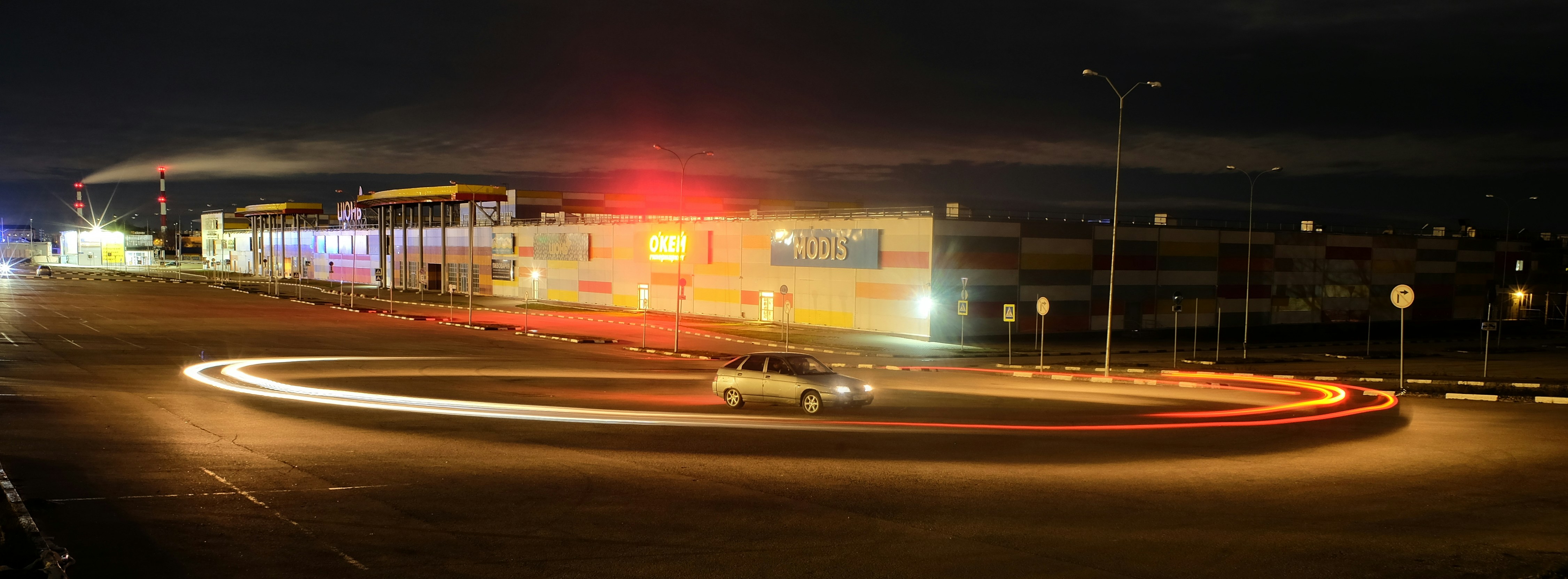 a car driving down a street at night