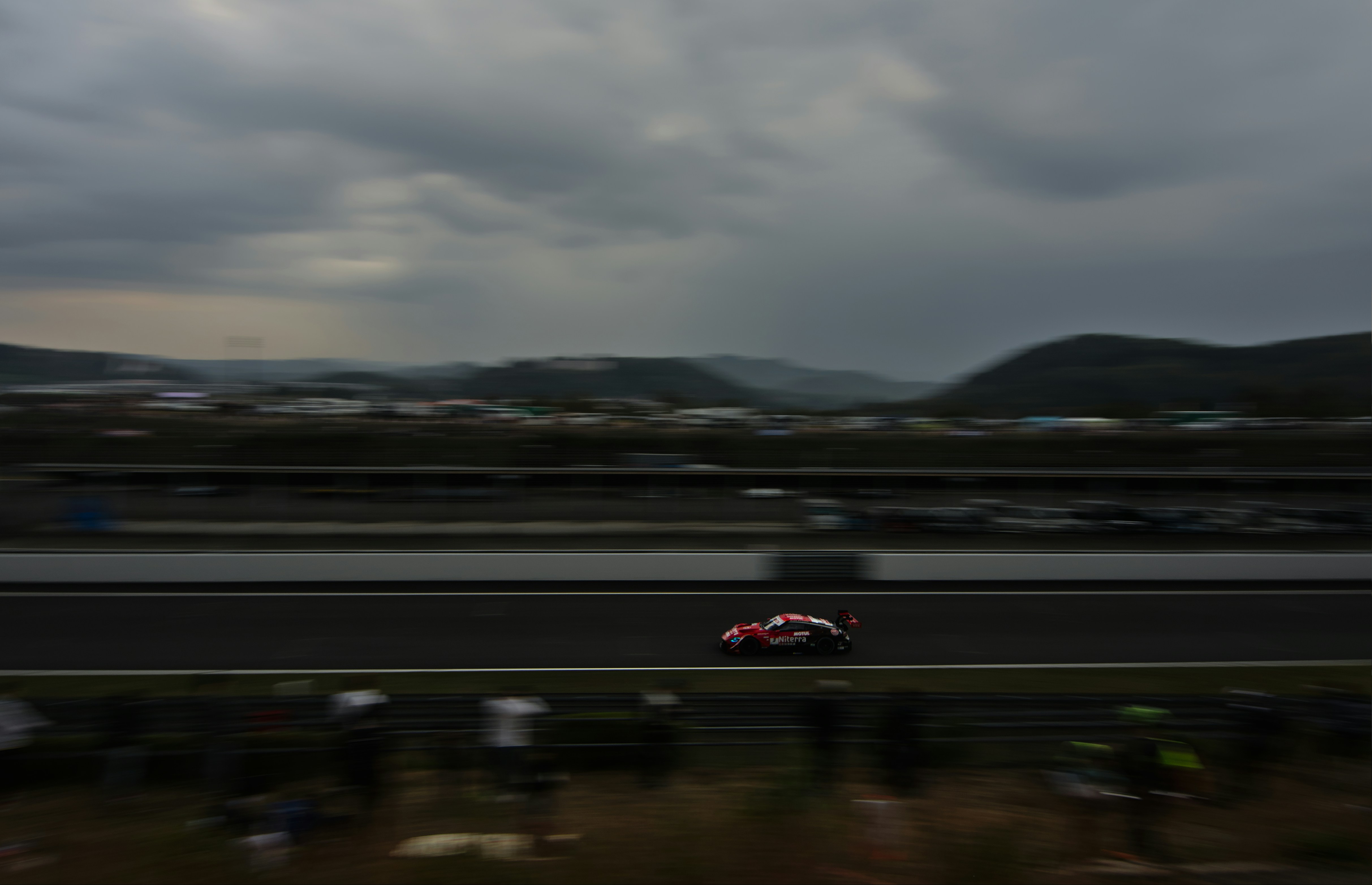 a car driving down a road under a cloudy sky