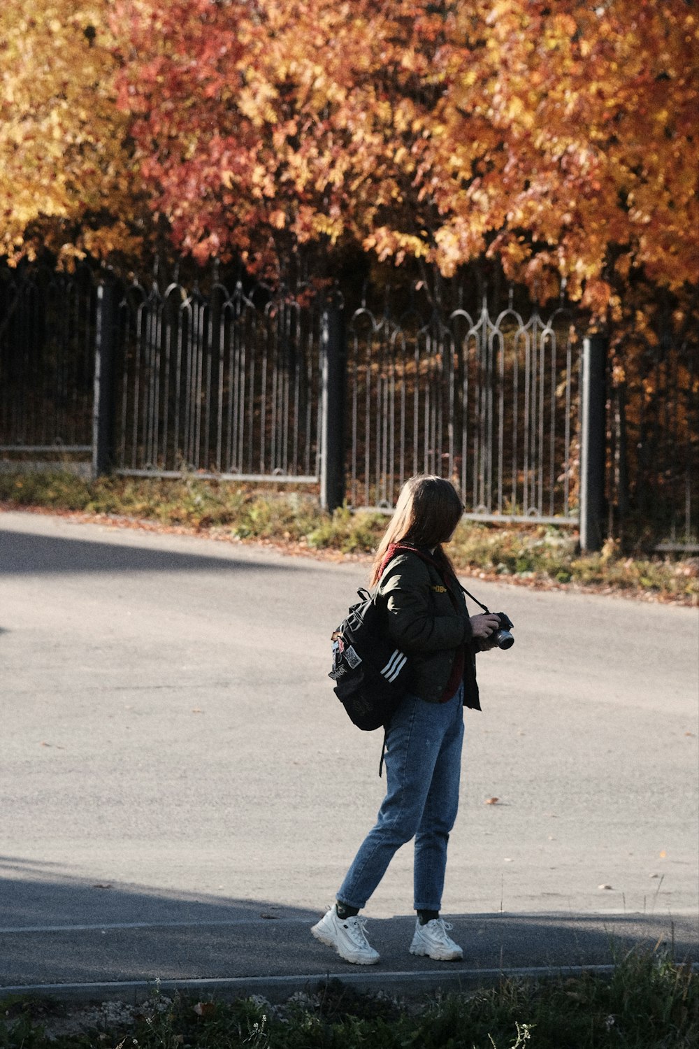 a woman walking down a street with a backpack