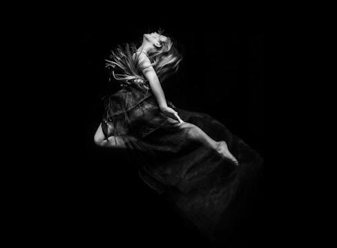 Artistic black and white shot of flowing fabric captured mid-air, evoking movement and grace.