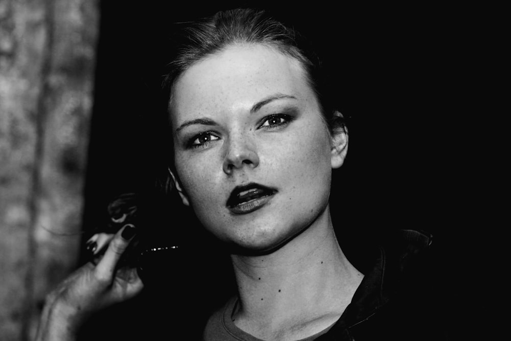 a black and white photo of a woman smoking a cigarette