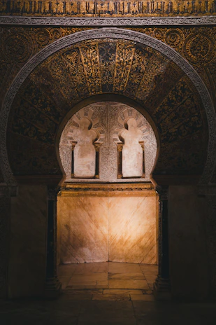 Elegant golden Islamic geometric archway softly illuminated against a deep emerald background.