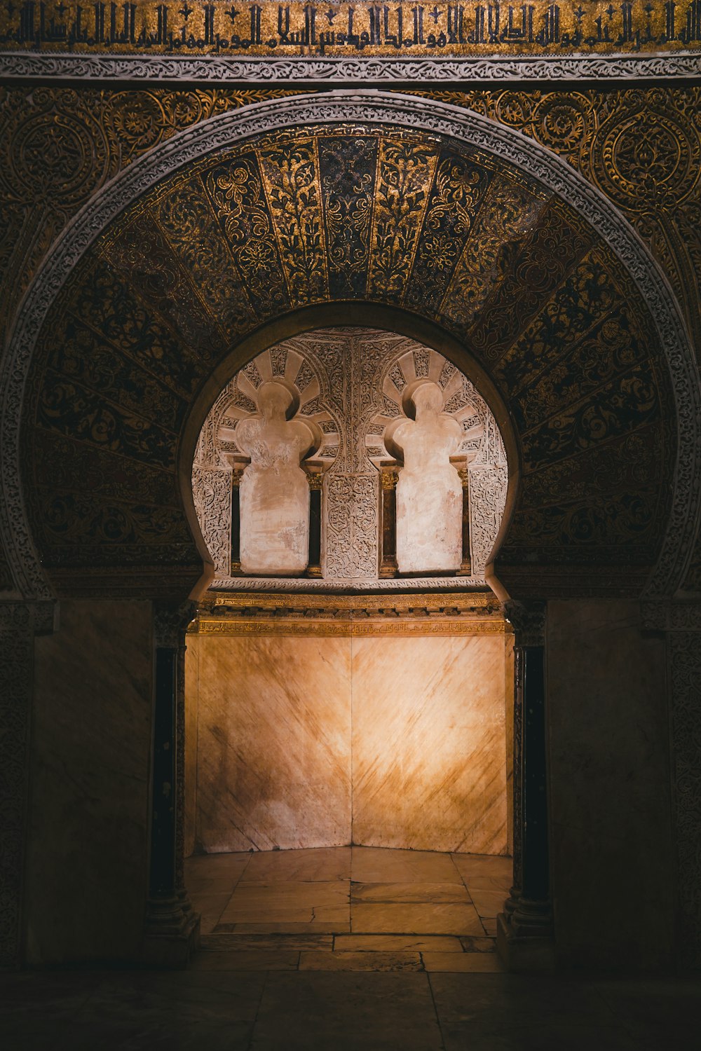 an arch in a building with a light shining through it