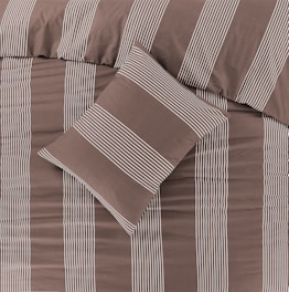 a bed with a brown and white striped comforter