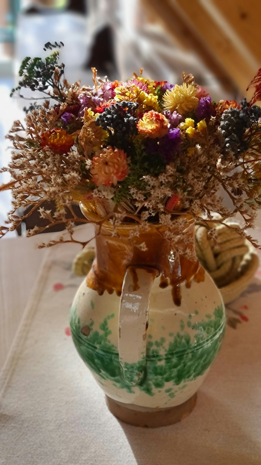 a vase filled with lots of colorful flowers on top of a table