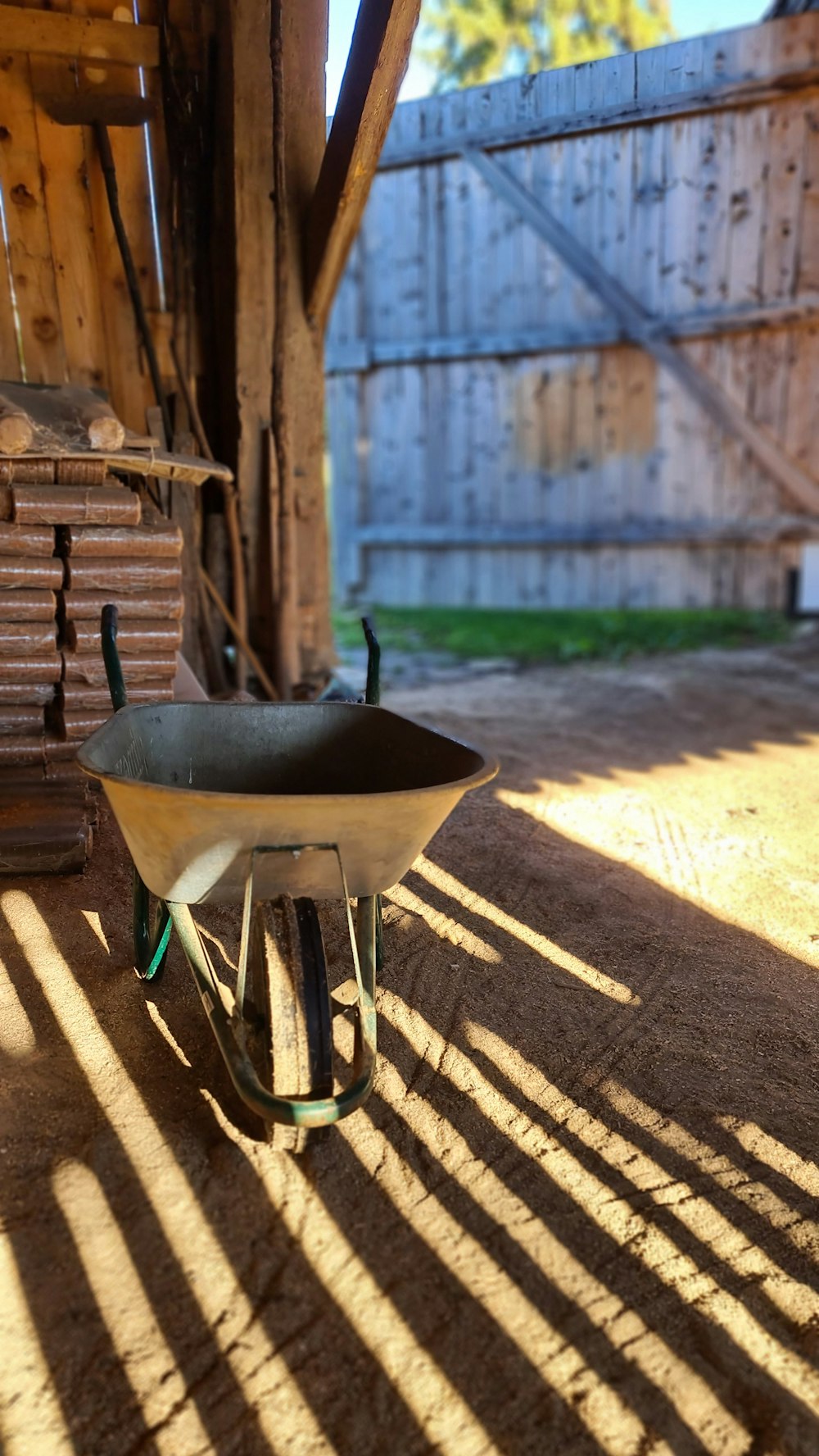 a wheelbarrow sitting in the shade of a building