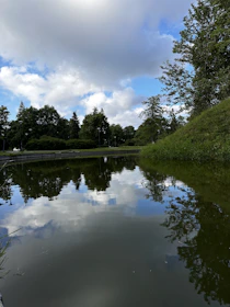 A serene pond reflecting the early morning sky beside the developing resort grounds.