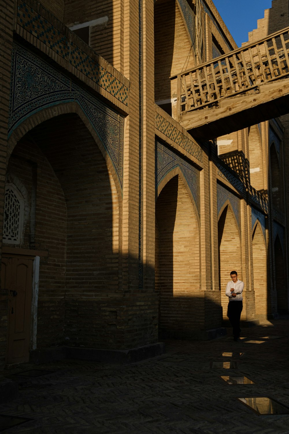 a man standing in front of a brick building