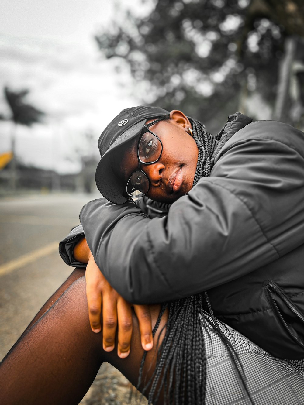 a woman sitting on the side of a road