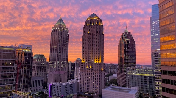 A modern city skyline at sunset with highlighted buildings and contact icons.