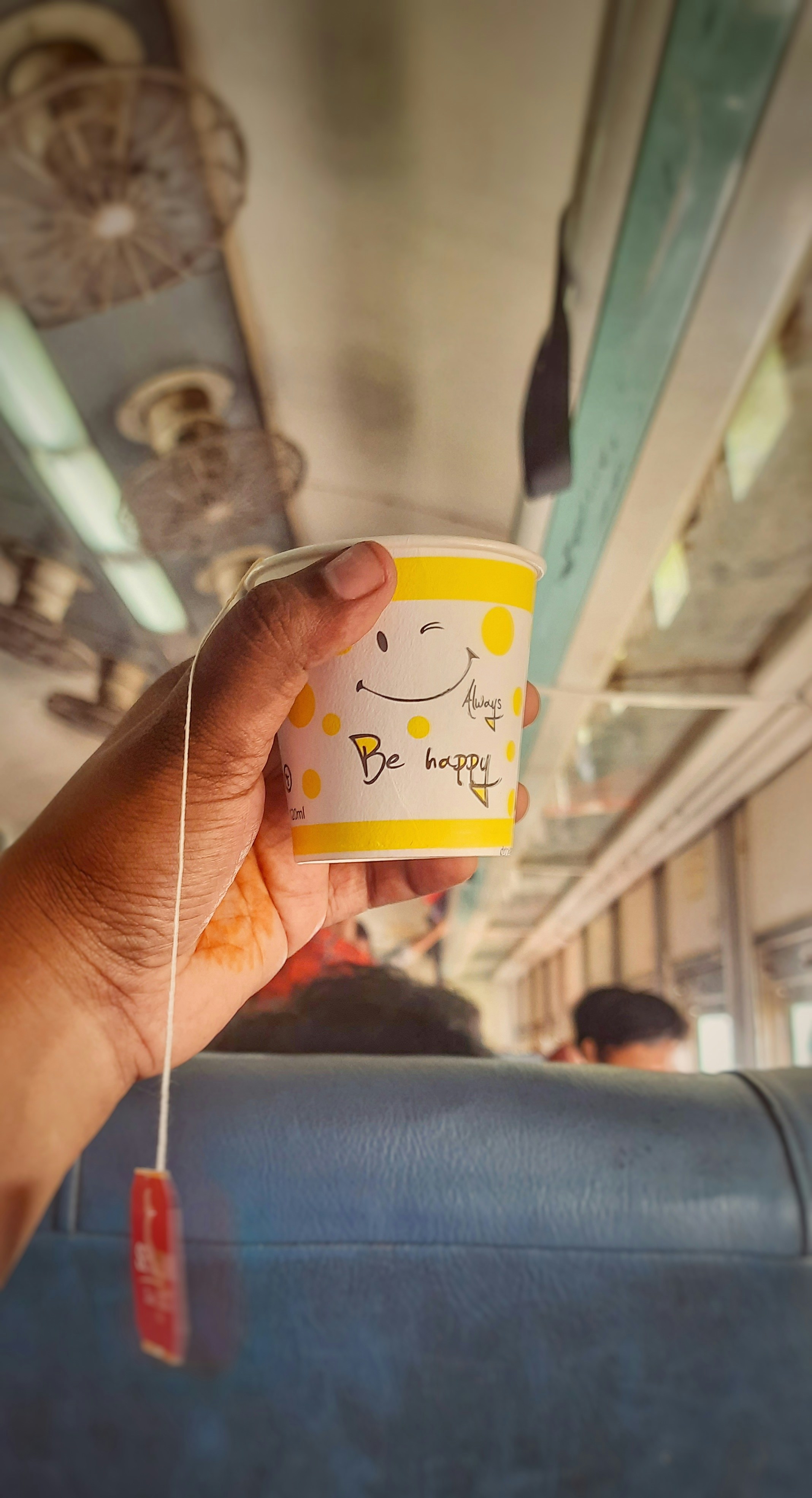 una mano sosteniendo una taza de café con una cara sonriente dibujada en ella