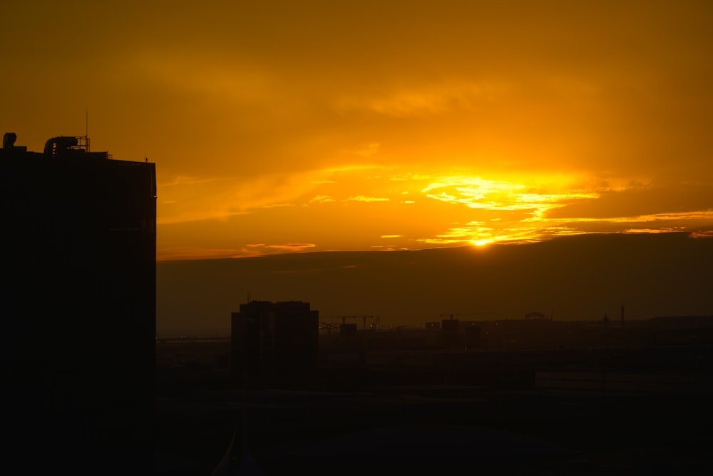 the sun is setting over a city with tall buildings