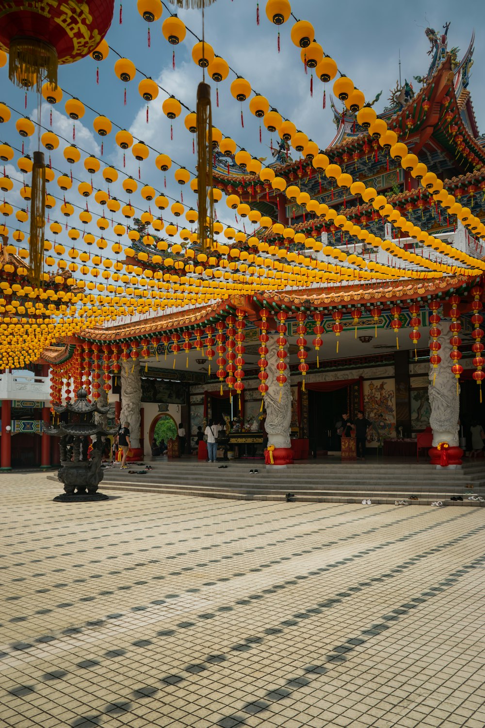 a group of yellow and red lanterns hanging from the ceiling
