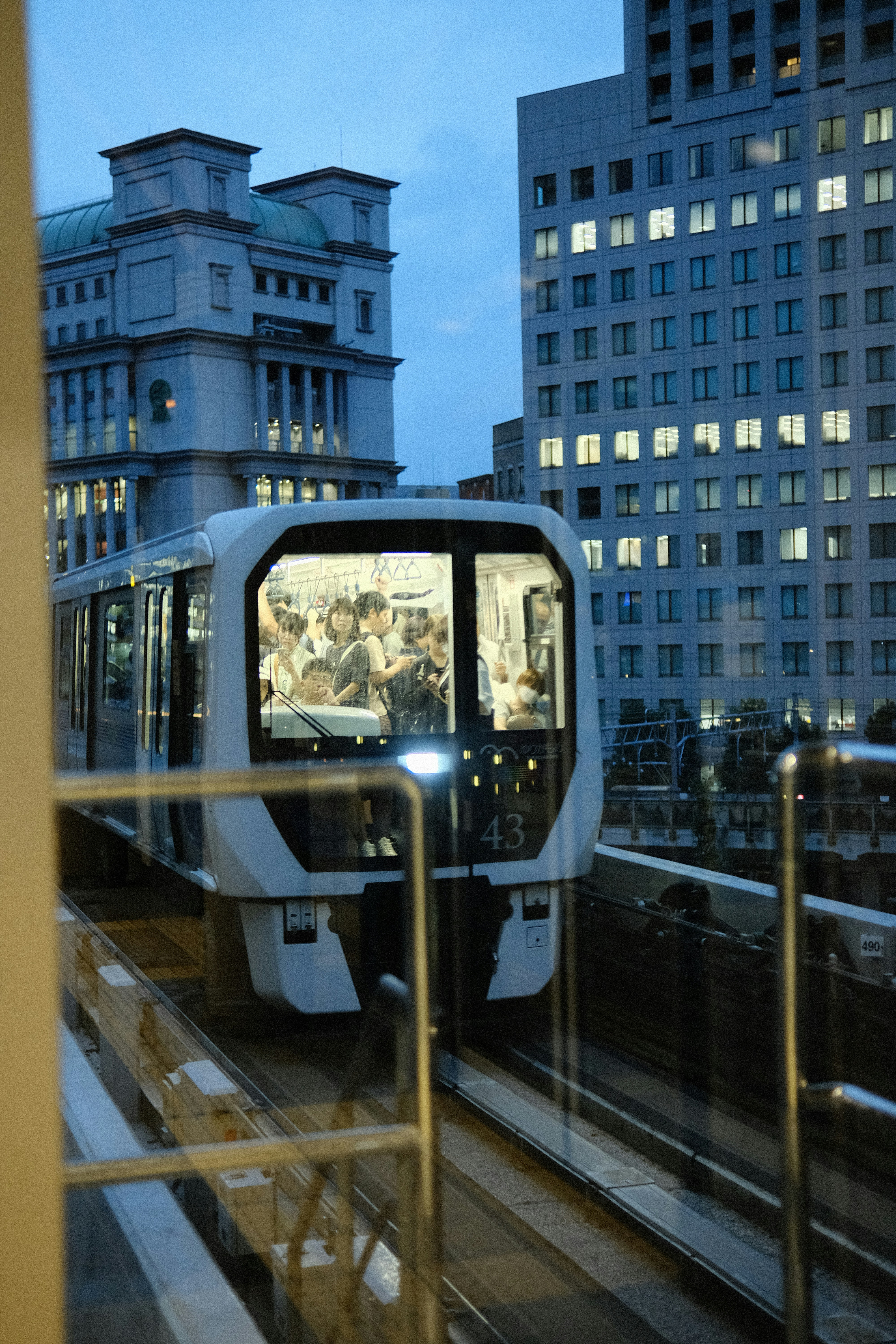 a train traveling down tracks next to tall buildings