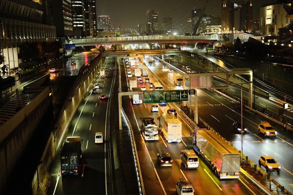 a highway filled with lots of traffic next to tall buildings