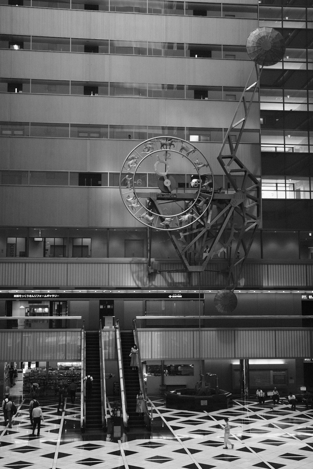 a black and white photo of a clock in a building