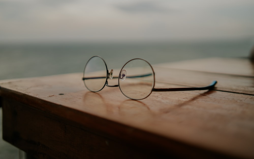 a pair of glasses sitting on top of a wooden table